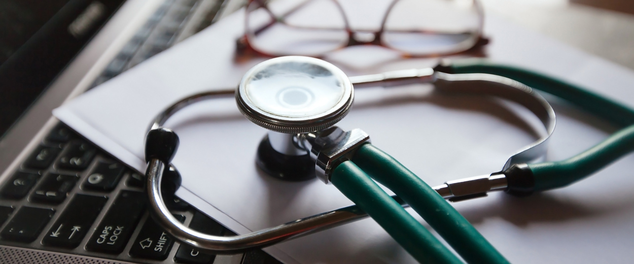 Stethoscope resting on a laptop computer